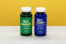 Load image into Gallery viewer, 92+ Day and Night System sea moss daily multivitamins immune support and sleep support bottles on wooden surface

